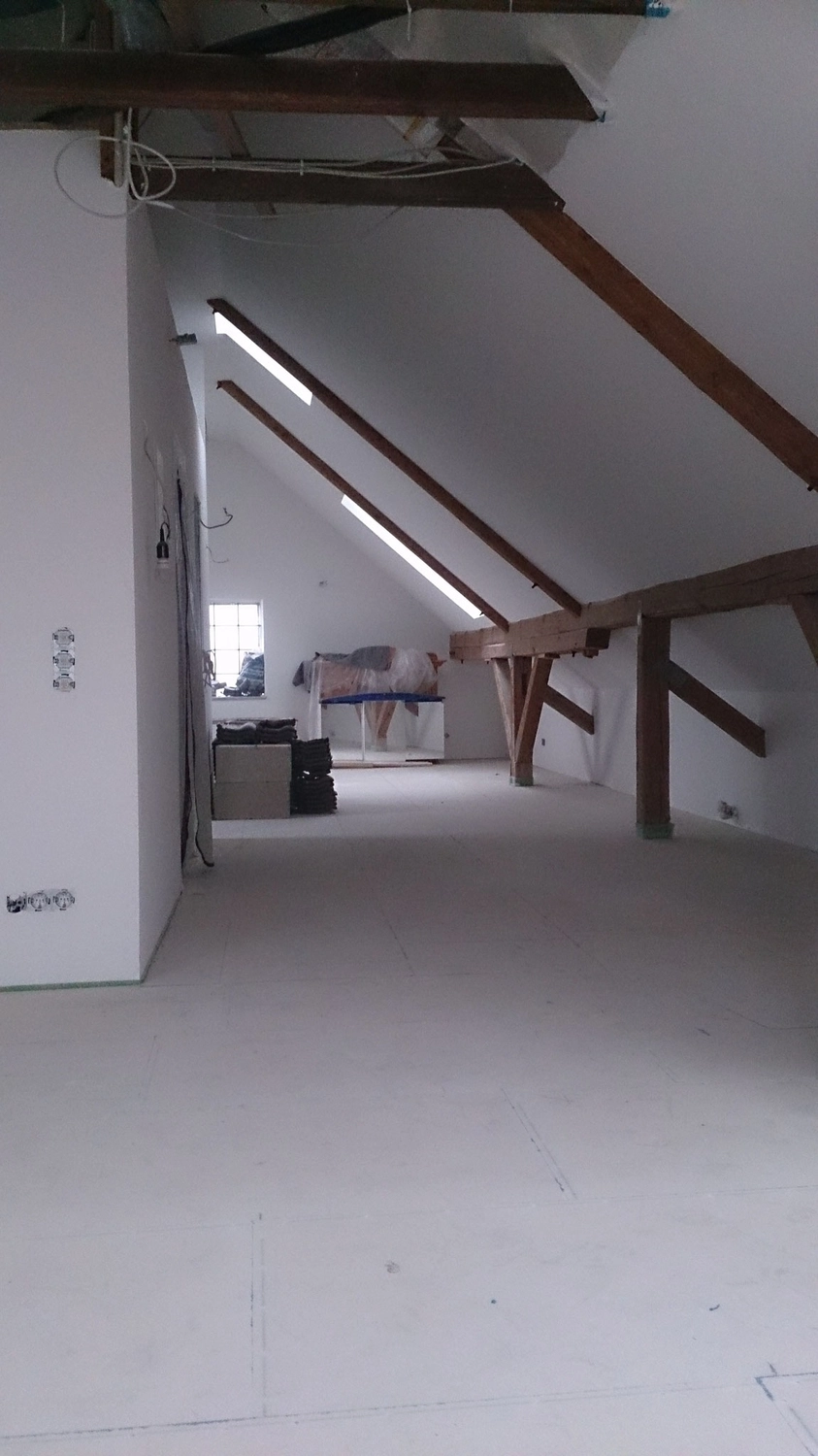 D.Förster - Innenarchitektur - Gesamtansicht der Ausbaufläche mit durchgehend vorbereitetem Bodenaufbau und großzügiger Raumwirkung im Dachgeschoss.